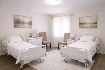 Bright shared room with two hospital beds and window