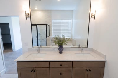 Bright modern bathroom with double sinks and a flower vase