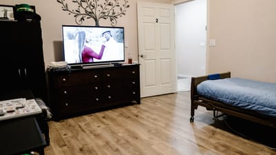 Private resident room with a bed and television