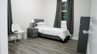 Cozy single bedroom with grey decor and natural light