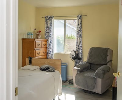 A private resident room with a bed and chair