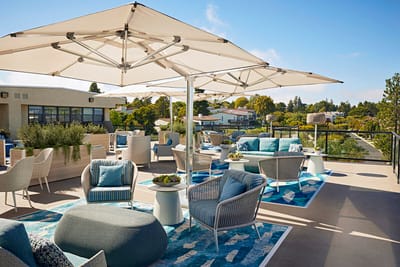 Outdoor rooftop lounge area with seating and shade