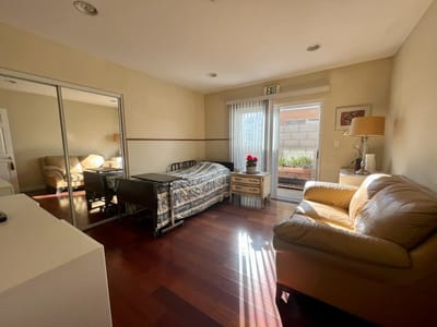 A cozy resident room with a bed and seating area