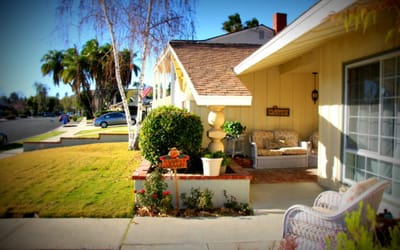 Exterior view of a residential facility with plants and seating.