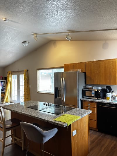 Brightly lit kitchen area with granite countertops