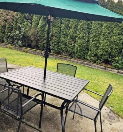 Outdoor patio table and chairs under an umbrella