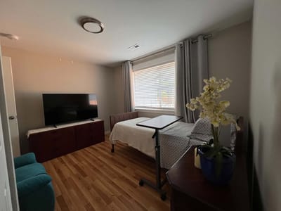 A cozy resident room with a bed and TV
