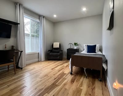 Well-lit resident room with wooden flooring and modern furnishings