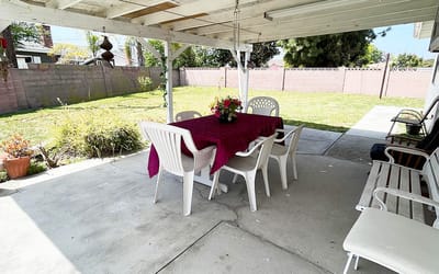 An outdoor patio area with a table and chairs