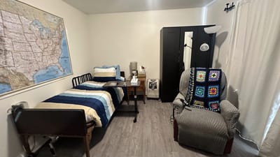 A private resident room with a bed and chair