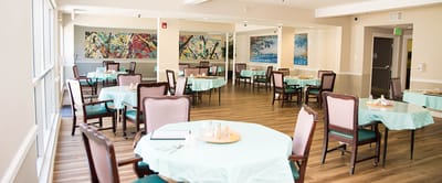 Bright dining room with tables set for residents