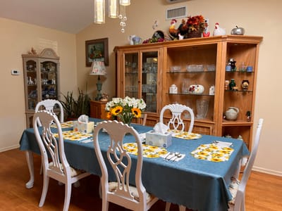 Bright dining area with floral table setting and decor.