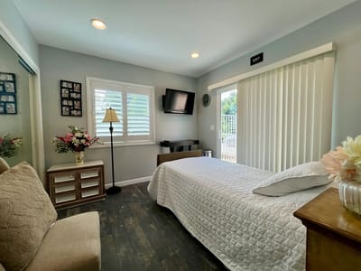 A well-furnished resident room with window and floral decor