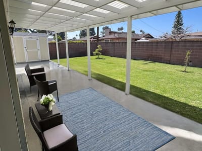 Outdoor patio area with seating and green lawn