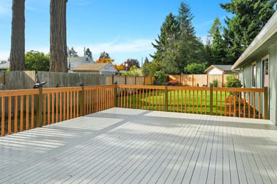 Outdoor wooden deck leading to a green lawn