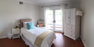 Private resident room with light decor and a bed
