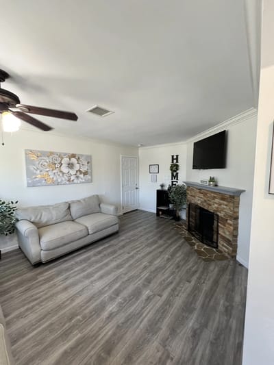 Bright common area with a cozy couch and fireplace