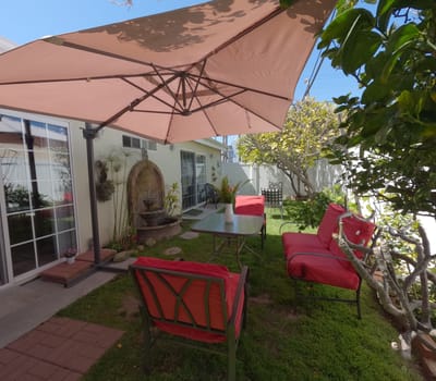 Outdoor seating area with red chairs and umbrella