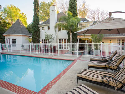 Outdoor pool area with lounge chairs and greenery