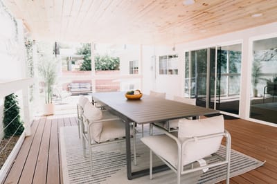 Outdoor patio space with seating and a bowl of fruit.