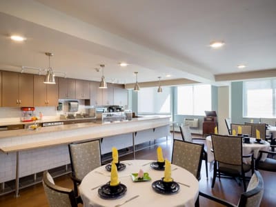 Dining area with set tables and kitchen in the background