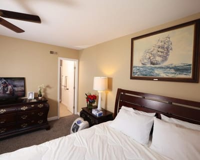 A well-furnished private room with a bed and artwork