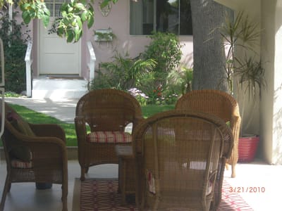 Outdoor seating area with wicker chairs and greenery