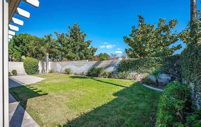 Well-maintained garden area with green lawn and trees