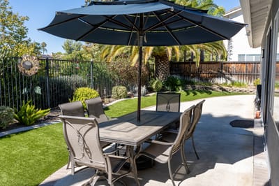 Outdoor patio with table and chairs under an umbrella
