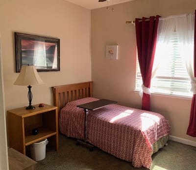 A cozy resident room with a bed and small desk