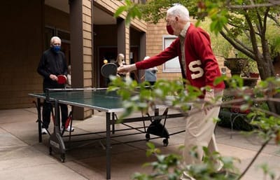 Residents playing table tennis in an outdoor area