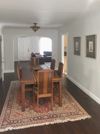 A dining area with a wooden table and chairs