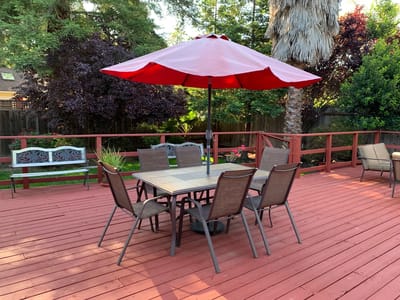 Patio area with table and chairs under an umbrella