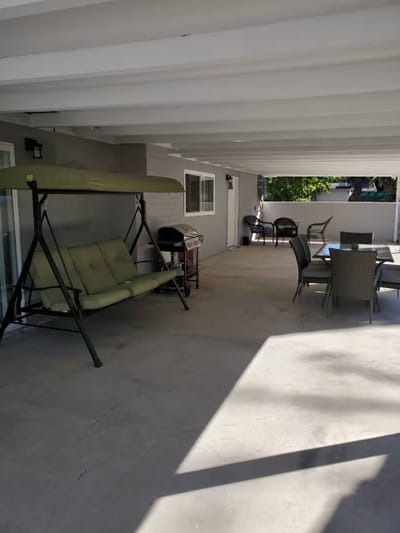Covered outdoor seating area with swing and dining table