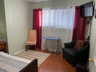 A private resident room with a chair and window