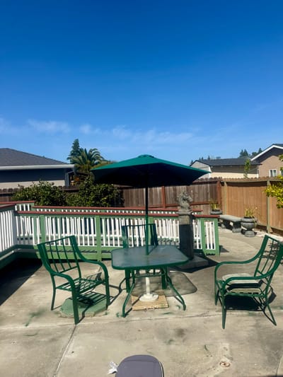 Outdoor seating area with a green umbrella and table