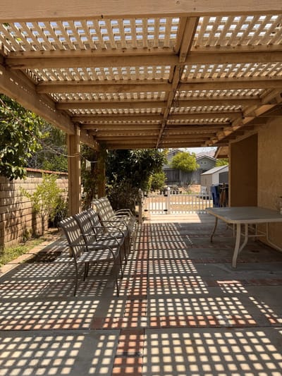 Covered outdoor seating area with natural light and shadows