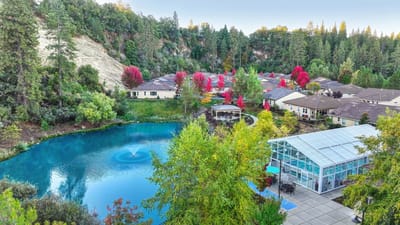 Aerial view of a vibrant senior living campus with a pond