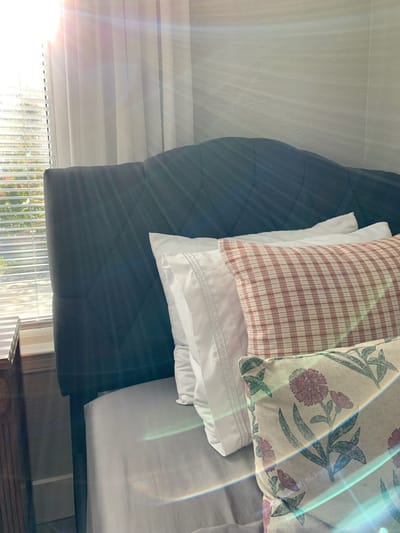 Decorated bed with various pillows in a room