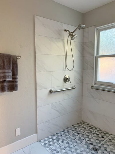 Accessible shower with grab bars and tiled walls