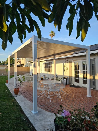 An outdoor patio area with white furniture and shade