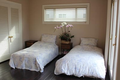 A cozy shared resident room with two beds and plants