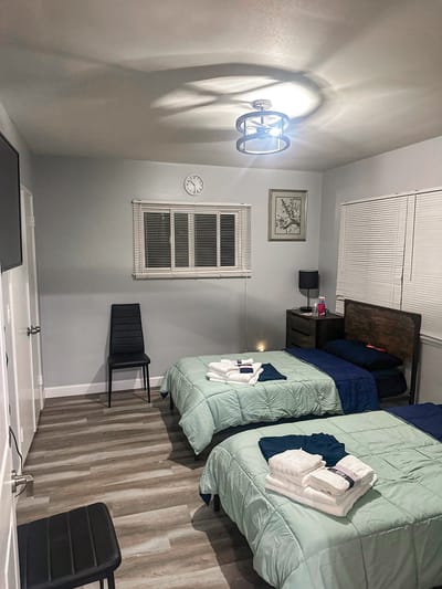 A shared resident room with two beds and light decor