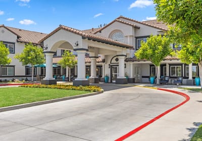 Building exterior of a senior living facility with landscaped entrance