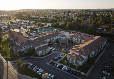 Aerial view of a senior living facility surrounded by greenery