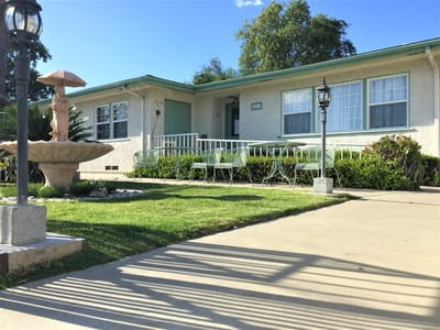 Exterior view of Francel Guest Home II with garden and benches