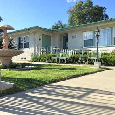 Exterior view of a senior living facility with outdoor seating