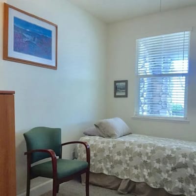 Cozy private resident room with a bed and chair