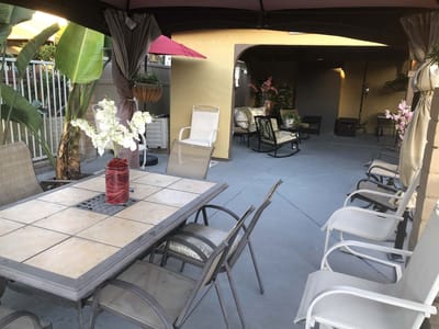 Outdoor seating area with tables and chairs under a canopy