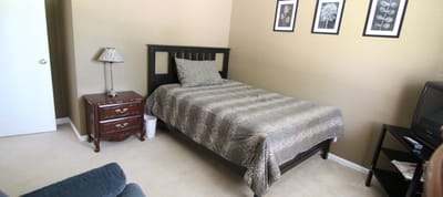 Bright private room with a bed and nightstand